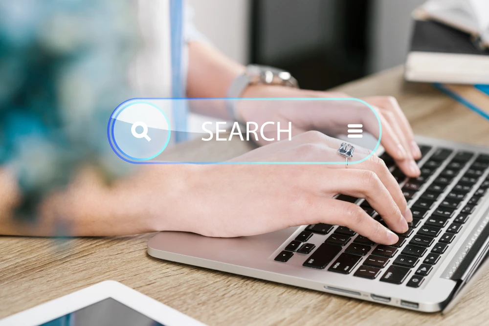 Imagem mostrando como os motores de busca realizam a pesquisa e indexação de sites. Um usuário digitando em um laptop com barra de pesquisa visível.