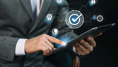 Homem de terno usando tablet com conceitos de segurança digital ilustrados em gráficos e símbolos relacionados ao Zero Trust na prática para pequenas empresas