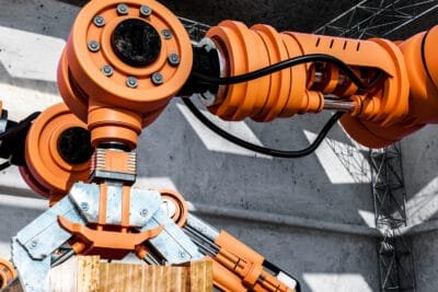 Robô industrial de carga usando uma talha elétrica de alta capacidade para movimentar uma carga pesada, destacando a importância do cálculo de carga adequado.